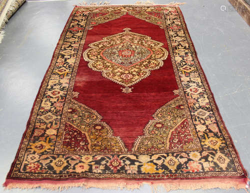 A Milas rug, Turkey, early 20th century, the shaded red field with a lobed medallion, within a