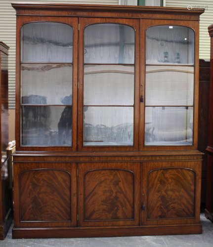 A late Victorian mahogany library bookcase cabinet by M. Wilson, London, the moulded pediment