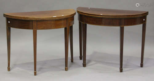 A near pair of 19th century mahogany demi-lune fold-over card tables, each hinged top revealing a