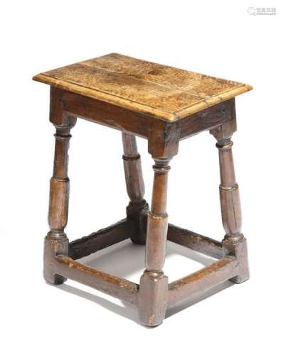 A 17th century oak joint stool, the later seat on …