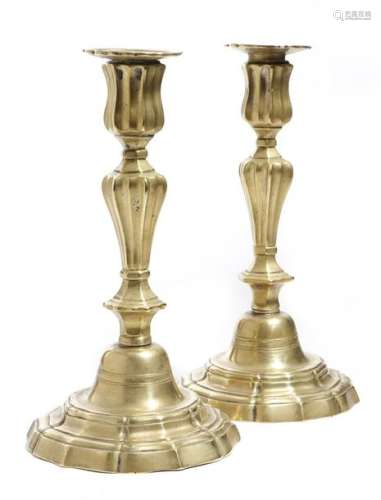 A pair of French Régence brass candlesticks, each …