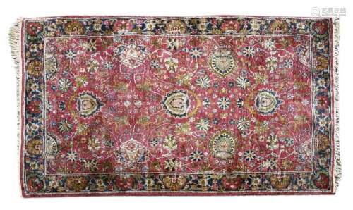 A Persian silk and woollen rug, the rose pink fiel…