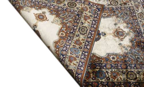 A Persian silk and woollen rug, the beige fields w…