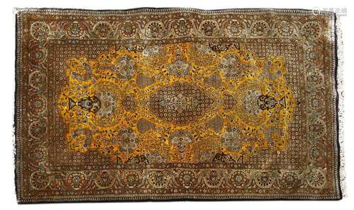 A Persian silk rug, the gold and navy fields with …