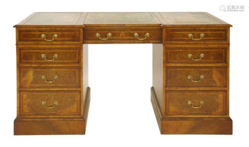A walnut breakfront pedestal desk, the green leath…