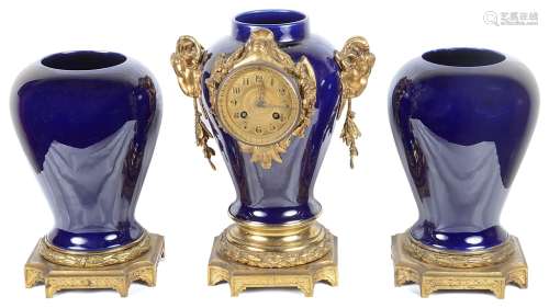 A 19th Century Clock Garniture: Clock set into blue ceramic urn with goat head finials,