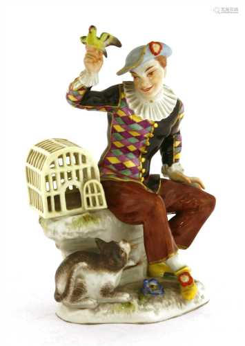 A Meissen figure of a seated harlequin