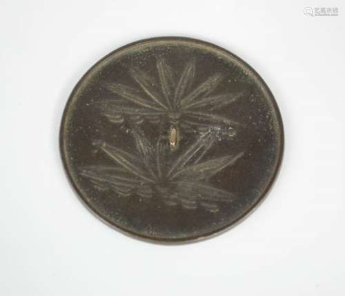 An Eastern Han Dynasty Chinese bronze mirror, 1-2nd century AD, depicting lotus leaves.