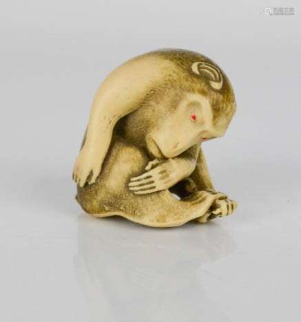 A resin netsuke monkey engraved with detail.