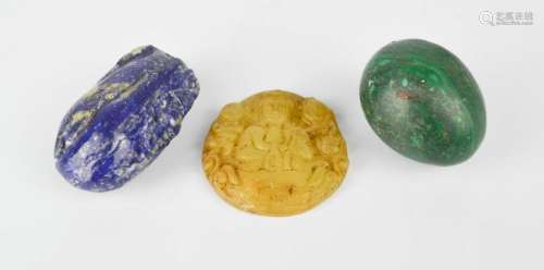 A lapis lazuli pendant, malachite egg, and a jade carved pendant.