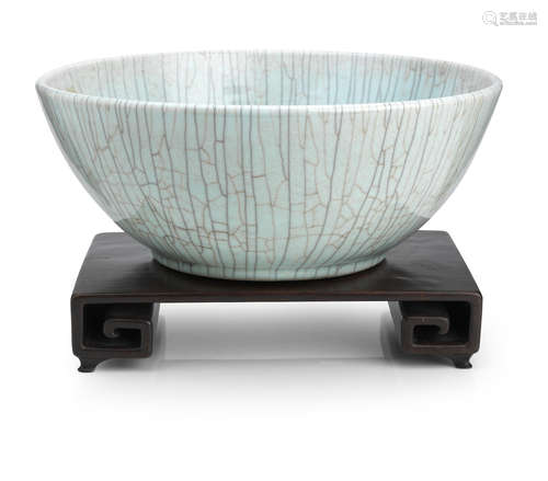 20th century A large crackle-glazed bowl and a scroll-form hardwood stand