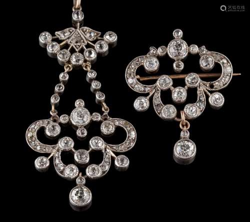 A diamond mounted pendant: of openwork foliate scroll design suspending a single round diamond drop