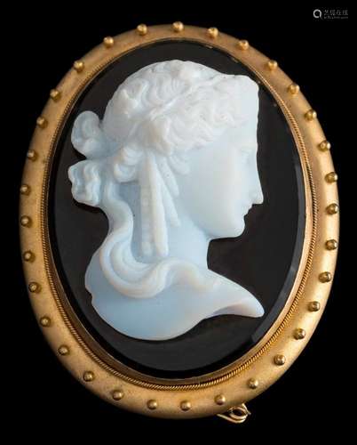 An oval glass cameo portrait brooch: with white glass portrait of a young woman on a black glass