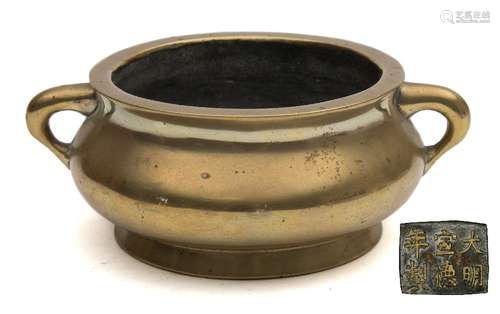 A Chinese cast bronze censer: of plain squat circular form with loop carrying handles to the sides,