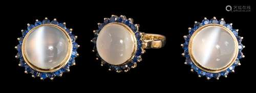 A cat's eye moonstone and sapphire circular cluster ring with matching ear-clips: each ear-clip