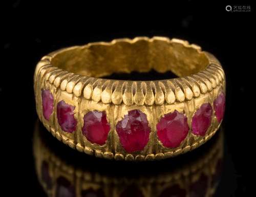 An antique gold and ruby seven-stone ring: with rounded oval rubies in a heavy rub-over setting,