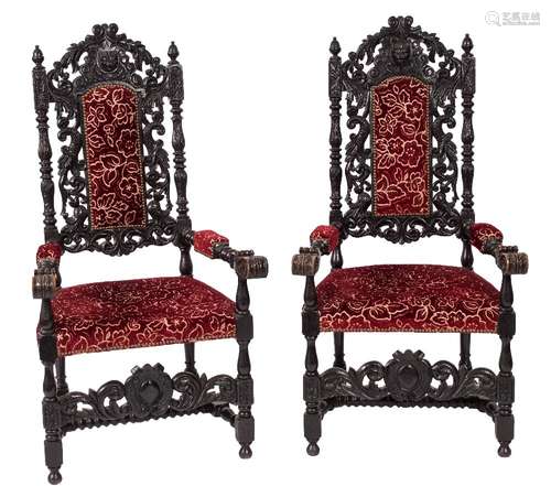 A pair of Victorian carved dark oak open armchairs:, in the Gothic taste,