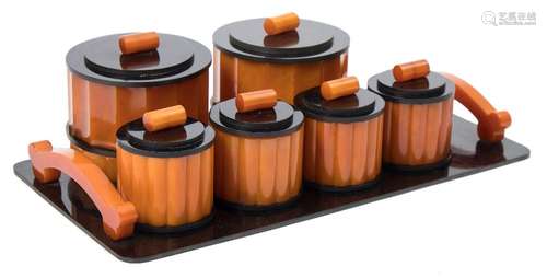 An Art Deco period nine piece orange and black bakelite dressing table set: includes scent bottle,