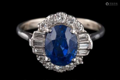 A fine sapphire and diamond oval cluster ring: with central oval sapphire 9.2mm long x 6.