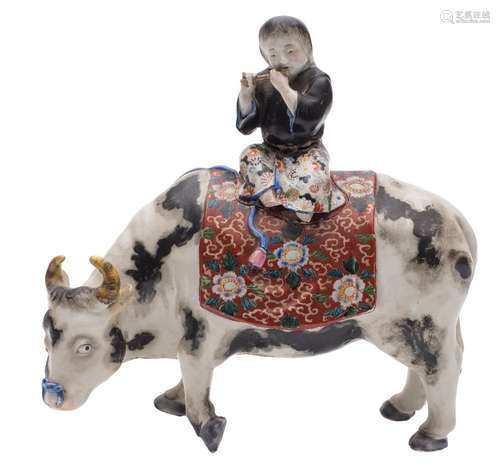 A Japanese porcelain koro and cover in the form of a boy on a water buffalo: with elaborate saddle