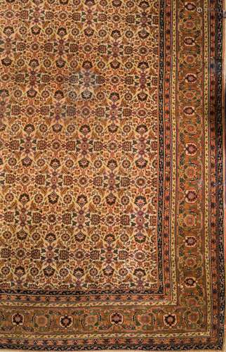 A Sivas carpet:, the beige field with an all over geometric palmette, medallion and leaf design,