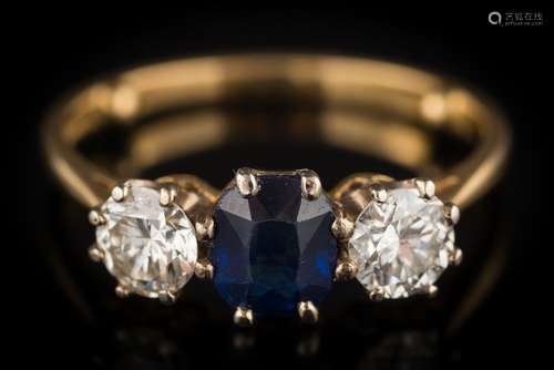 A sapphire and diamond three-stone ring: the central oval sapphire approximately 6mm long x 5.