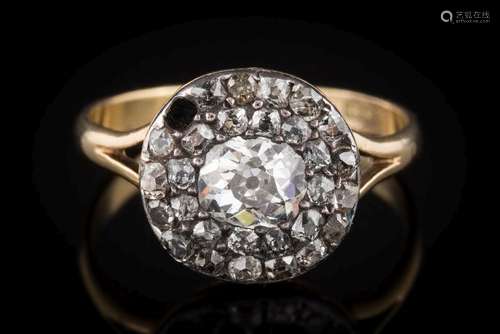 A diamond mounted round cluster ring: with a central oval,