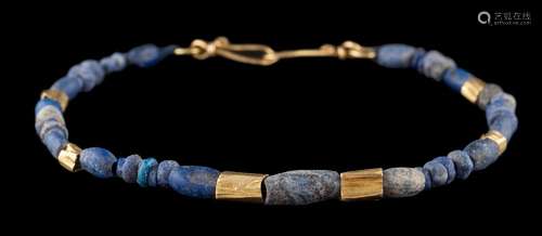 A gold and lapis lazuli bead single-string bracelet.