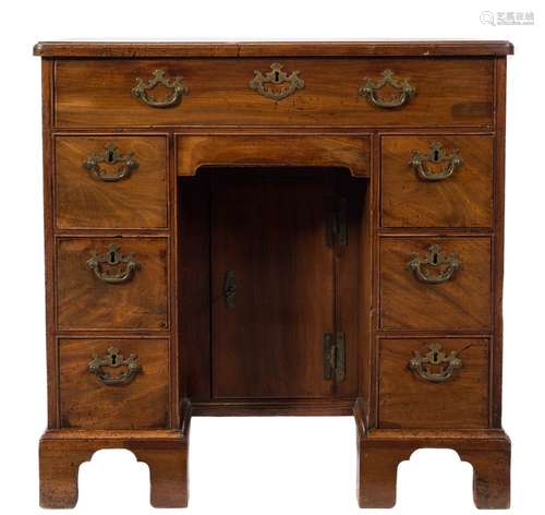 A George III mahogany kneehole desk:, the top with a moulded edge and rounded corners,