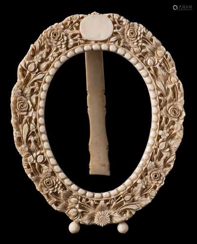 A late 19th century Continental ivory oval frame: carved with a vacant cartouche within a