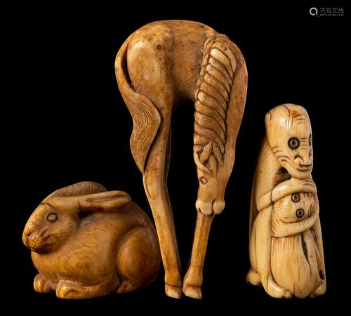 Two Japanese ivory netsuke and a similar okimono: the netsuke in the form of a monkey clutching its