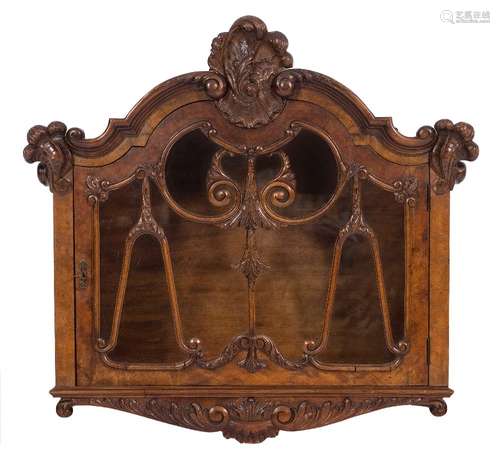 A carved walnut wall mounted display cabinet:,