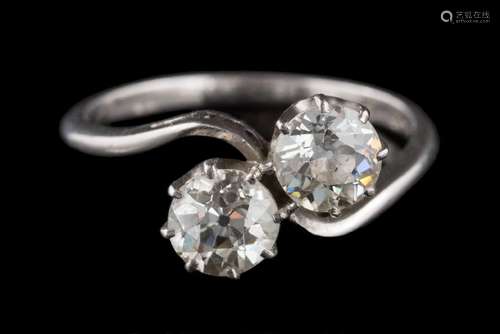 A diamond two-stone cross-over ring: the round old brilliant-cut diamonds in claw settings,