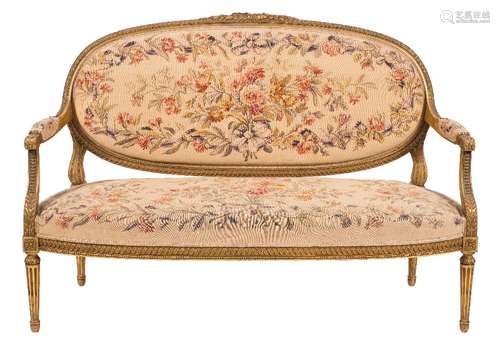 A French carved giltwood and tapestry canape in the Louis XV/XVI transitional taste:, the oval back,