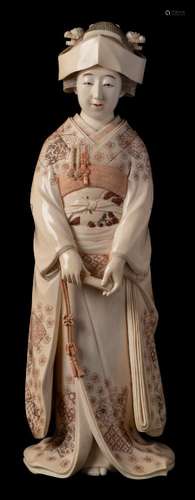 An early 20th century Japanese ivory okimono of a Geisha: wearing traditional floral decorated