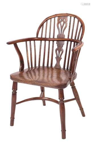 An early 19th century yew wood and elm stick back Windsor elbow chair: the arched back with a