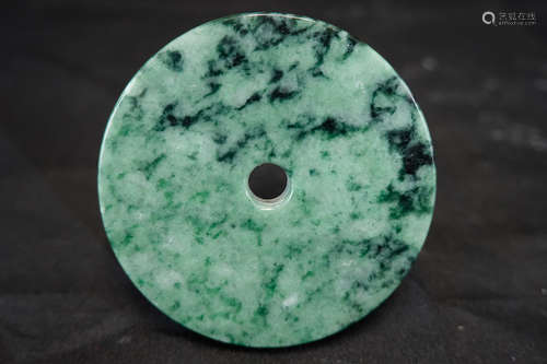 A JADEITE ROUND TABLET WITH COLORATION PATTERN