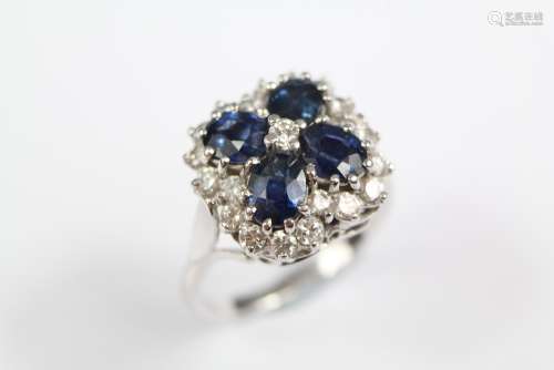 An 18ct White Gold Sapphire and Diamond Ring; the ring having four oval sapphires approx 6 x 4 mm, surrounded by approx 3 cts of brilliant-cut diamonds, size Q, approx 8
