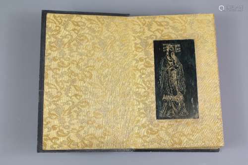 A Chinese Hardstone Book of Buddhist Sutra, eight pages, including thirteen dark green and gold stone plaques and two carved wooden covers, the back page depicting    and the front page a       , all engraved with gilt, each plaque approx 7 x 13 cms