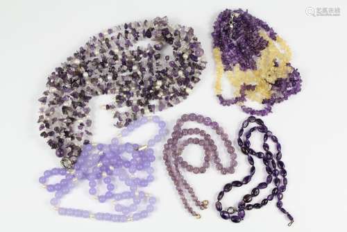 Purple Quartz Amethyst and Glass Bead Necklaces: a four-strand drop necklace, approx 40 cms, a three-strand drop necklace, approx 50 cms, a two-strand amethyst and pearl necklace, approx 40 cms, a single-strand amethyst necklace, approx 110 cms and a carved amethyst necklace, approx 50 cms