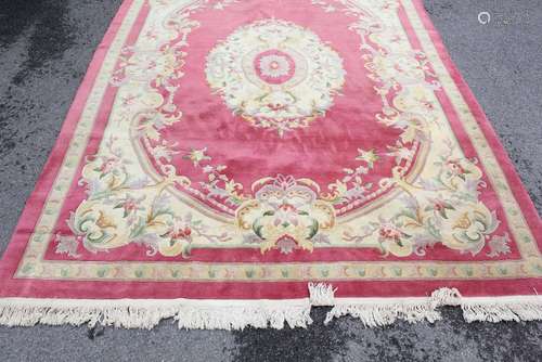 A Washed Chinese Carpet; the carpet having a pink ground with beige floral border, approx 250 x 350 cms