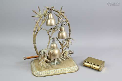 A Brass Decorative Table Bell: the unit having four bells set in decorative leaf design, on brass base with decorative edge and strike, together with a brass box in the form of a book with bead edge cover, approx 7