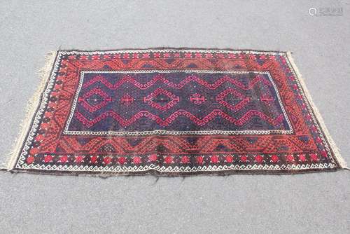 A Turkish Wool Carpet, claret ground with navy blue and cream geometric design, approx 115 x 200 cms, selvedges and tassels with some imperfection