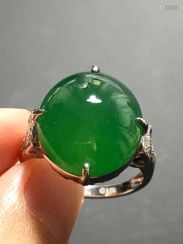 A GREEN JADEITE CARVED CIRCLE FINGER RING