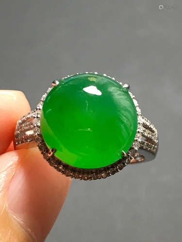 A GREEN JADEITE CARVED CIRCLE FINGER RING