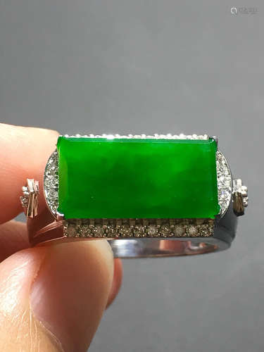 A GREEN JADEITE CARVED SADDLE RING