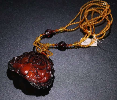 A FLOWER CARVED BLOODY AMBER PENDANT