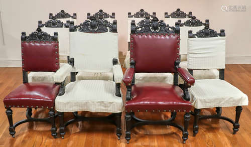 Antique Spanish-style carved walnut dining chairs having leather seats, two arm chairs and ten