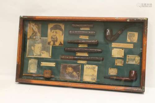 A display case of simulated cigars and pipes