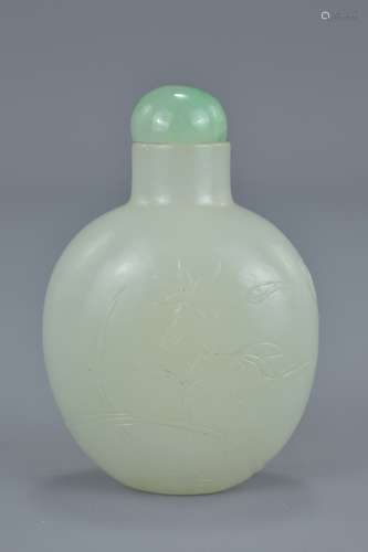 A Chinese 18/19th century mutton fat jade snuff bottle with inscided decoration of bat, cloud and fl